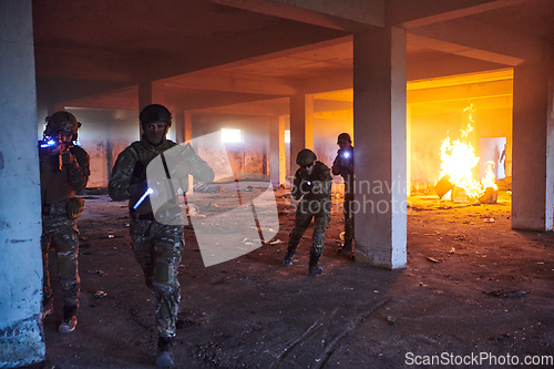 Image of A group of professional soldiers bravely executes a dangerous rescue mission, surrounded by fire in a perilous building.