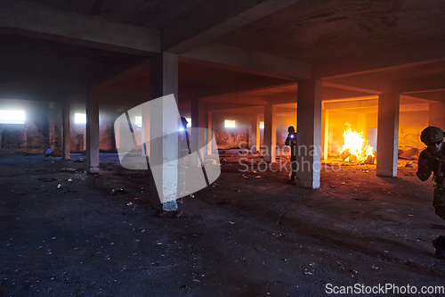 Image of A group of professional soldiers bravely executes a dangerous rescue mission, surrounded by fire in a perilous building.