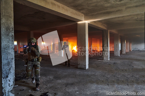 Image of A group of professional soldiers bravely executes a dangerous rescue mission, surrounded by fire in a perilous building.