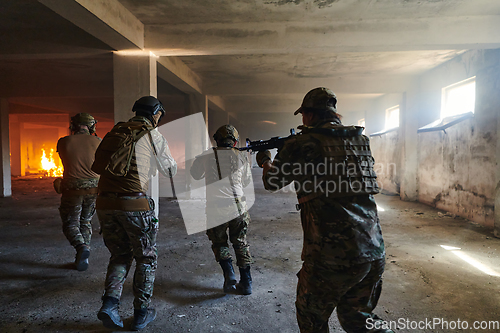 Image of A group of professional soldiers bravely executes a dangerous rescue mission, surrounded by fire in a perilous building.