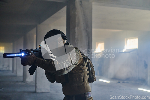 Image of A professional soldier in an abandoned building shows courage and determination in a war campaign