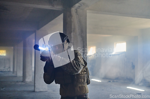 Image of A professional soldier in an abandoned building shows courage and determination in a war campaign