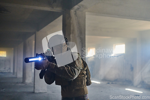 Image of A professional soldier in an abandoned building shows courage and determination in a war campaign