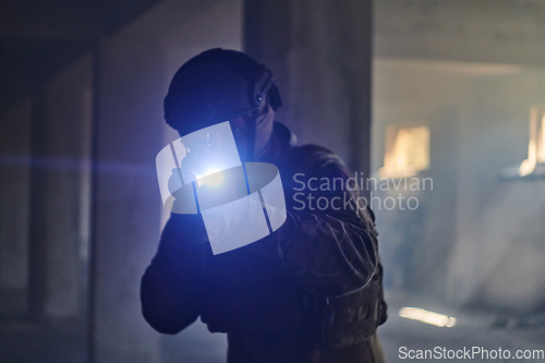 Image of A professional soldier in an abandoned building shows courage and determination in a war campaign