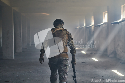 Image of A professional soldier in an abandoned building shows courage and determination in a war campaign