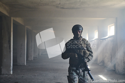 Image of A professional soldier in an abandoned building shows courage and determination in a war campaign