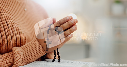 Image of Closeup hands, rosary and a bible for prayer, spiritual support and hope from Jesus. House, God and a person with a cross and book for help, trust and gratitude as a Christian for the gospel