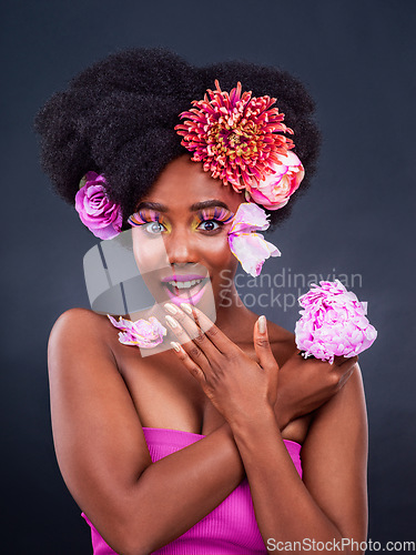 Image of My secret is out. Studio shot of a beautiful young woman posing with flowers in her hair.