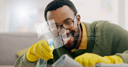 Image of Cleaning, happy and man with spray for furniture in living room for hygiene, housework and maintenance in home. Housekeeping, products and person with gloves for bacteria, dirt and dust on surface