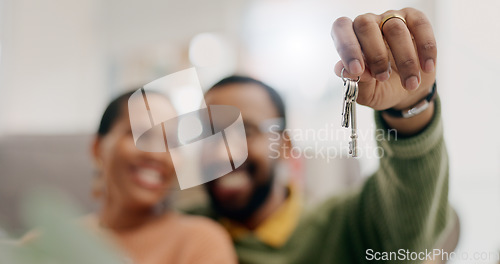 Image of Hand, keys and couple with closeup in new home for fresh start, property or real estate investment with smile. African man, woman and happy for apartment, house and mortgage in blurred living room