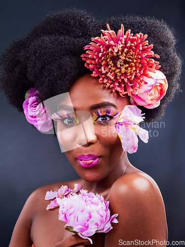 Image of Why fit in when makeup can make you stand out. Studio shot of a beautiful young woman posing with flowers in her hair.