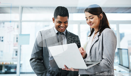 Image of Leave the desks behind in last century. a young businessman and businesswoman using a laptop in a modern office.