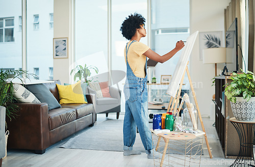 Image of I paint to relax my mind. a young artist painting on a canvas at home.