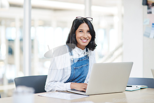 Image of Im getting so much done today. Portrait of a young businesswoman using a laptop in an office.