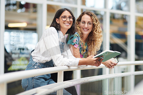 Image of Being organised makes everything else easier. Portrait of two businesswomen going through a notebook together in an office.