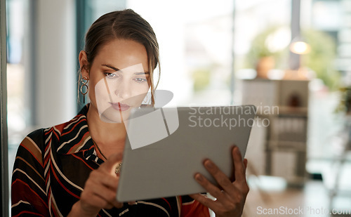 Image of Tapped into her target audience. a young businesswoman using a digital tablet in a modern office.