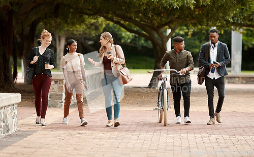 Image of Success belongs to the willing. a group of young businesspeople chatting while walking through the city.