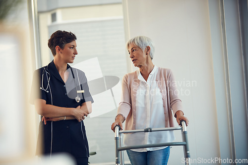 Image of Shes found a helping hand and a listening ear. a senior woman having a discussion with a young female nurse while using a walker in a nursing home.