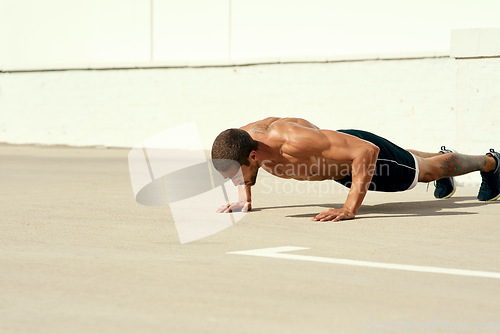 Image of No one will push you, thats your job. a sporty young man doing pushups as part of his exercise routine.