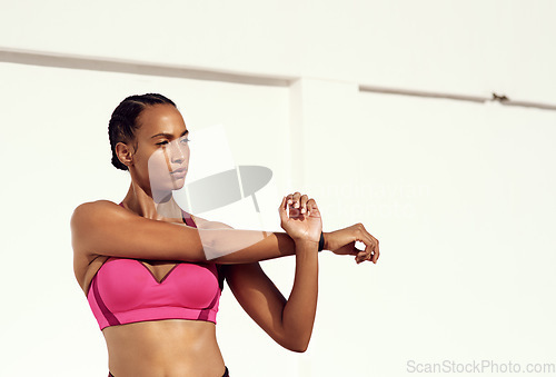 Image of Getting warmed up for her workout. a sporty young woman stretching as part of her exercise routine.