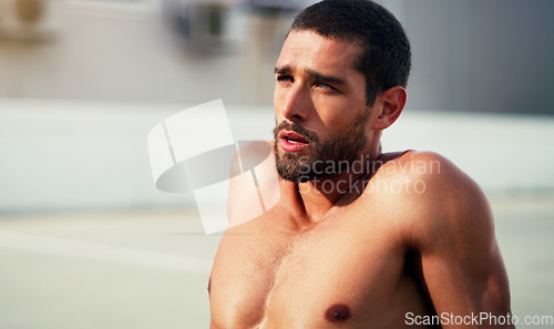 Image of Exhaustion is proof that youre doing well. a handsome shirtless young sportsman taking a break after a workout outdoors.