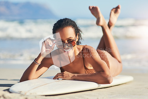 Image of Theres nothing cooler than a girl who can surf. a young woman out at the beach with her surfboard.