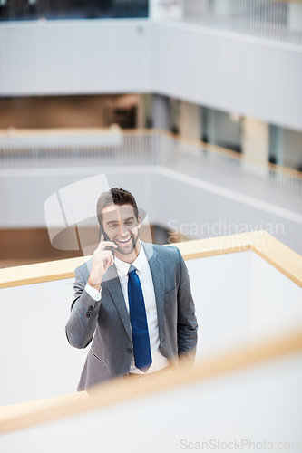 Image of Lets meet up and make it happen. a young businessman talking on a cellphone in an office.