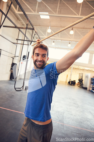 Image of Sculpting the perfect body with high-intensity workouts. a handsome young man working out with a stick in the gym.