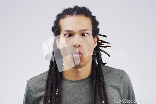 Image of There’s a time for being normal…that time’s not now. Studio shot of a young man making a funny face against a gray background.