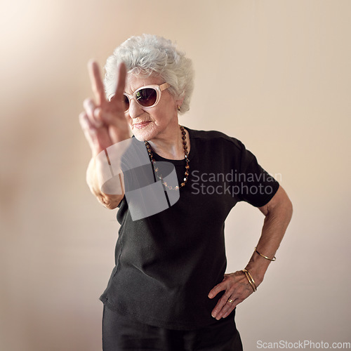 Image of Nothing’s more cool than old school. a cool senior woman wearing sunglasses and showing a peace gesture.