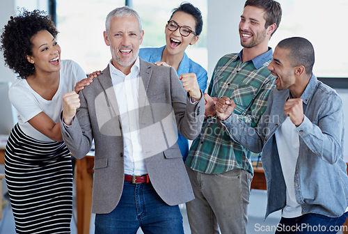 Image of Teamwork made this happen. a group of happy coworkers celebrating standing in an office.