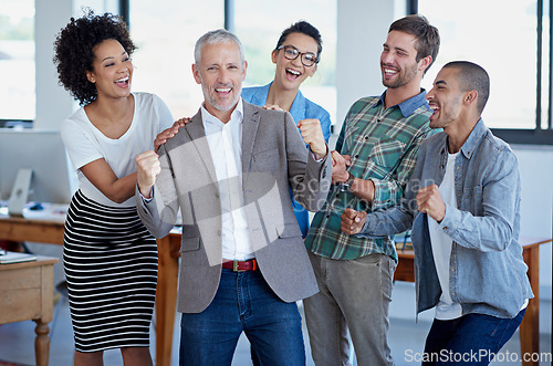 Image of Another business success story. a group of happy coworkers celebrating standing in an office.