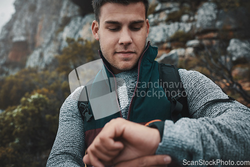 Image of So much world, so little time. a young man checking the time while out on a hike.