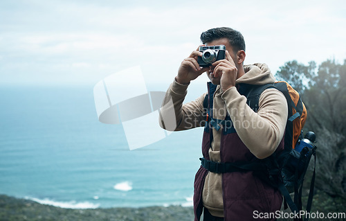 Image of Be a true traveller, not a temporary tourist. a young man taking photos while out on a hike.