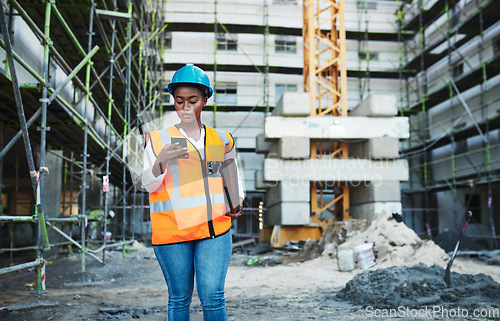 Image of Client satisfaction under construction. a young woman using a smartphone while working at a construction site.