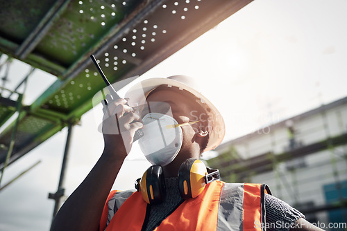 Image of Its a beautiful day to build your dream. a young woman using a walkie talkie while working at a construction site.