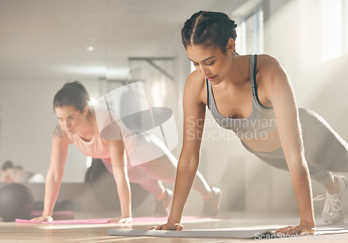 Image of Rise above your excuses. two female athletes doing push ups at the gym.