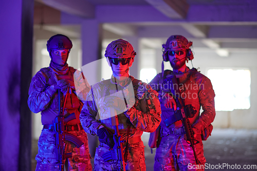 Image of Soldier squad team walking in urban environment colored lightis