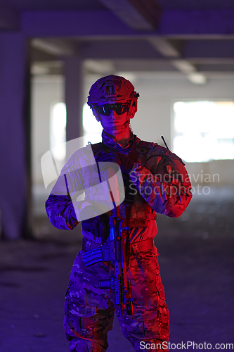 Image of A professional soldier undertakes a perilous mission in an abandoned building illuminated by neon blue and purple lights