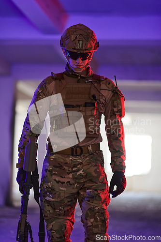 Image of A professional soldier undertakes a perilous mission in an abandoned building illuminated by neon blue and purple lights