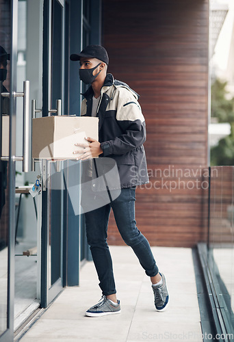 Image of Hello, your delivery is here. a masked young man delivering a package to a place of residence.