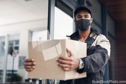 Image of In times of uncertainty you can count on our service. a masked young man delivering a package to a place of residence.