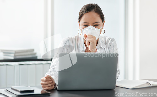 Image of Companies and humanity, we’re all just trying to survive. a masked young businesswoman coughing while working at her desk in a modern office.