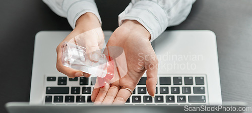 Image of Stay protected, stay productive. a businesswoman using hand sanitiser while using a laptop in a modern office.