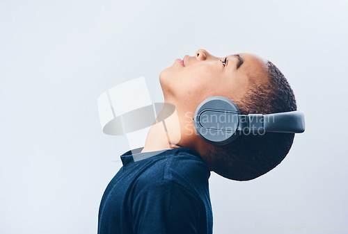 Image of Lean back and let the music take over. Studio shot of a cute little boy using headphones against a grey background.
