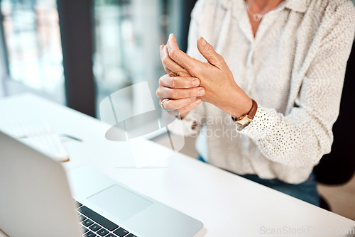 Image of Trying to loosen the stiffness in her hands. Closeup shot of an unrecognisable businesswoman experiencing discomfort in her hand while working in an office.