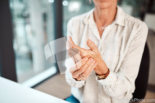 Image of Dealing with hand pain and stiffness. Closeup shot of an unrecognisable businesswoman experiencing discomfort in her hand while working in an office.