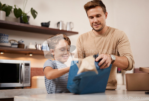 Image of I cant wait to see whats inside. a boy opening a gift from his father at home.