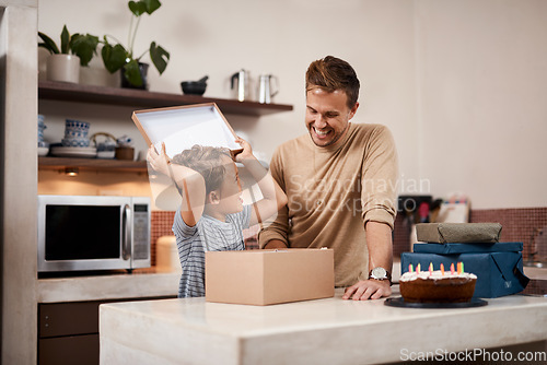 Image of You got me just what I wanted. a man surprising his son with cake and gifts on his birthday.