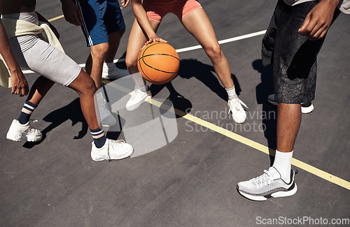 Image of Showcasing some fancy footwork on the court. Closeup shot of a group of sporty young people playing basketball on a sports court.